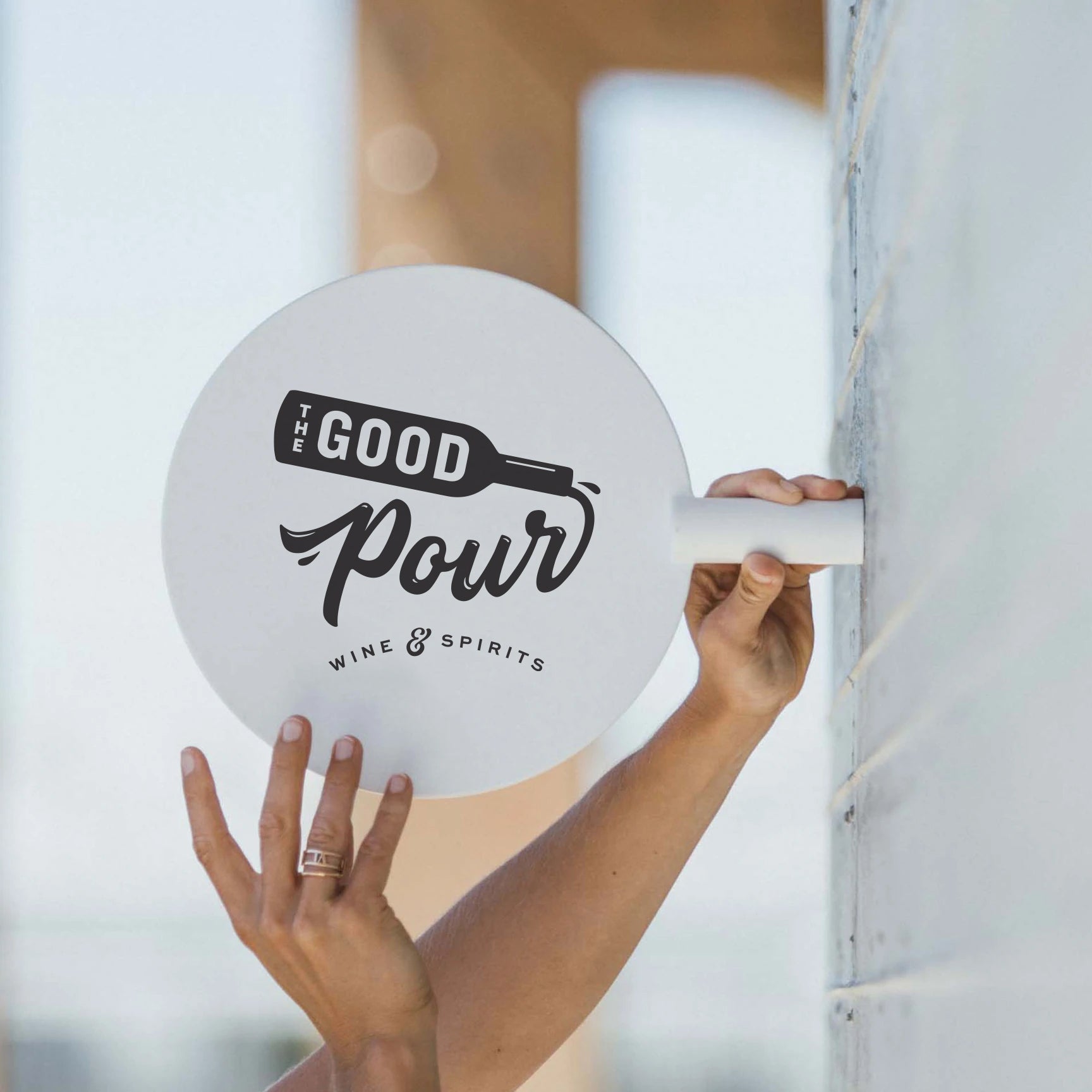 Hand holding sign with The Good Pour logo