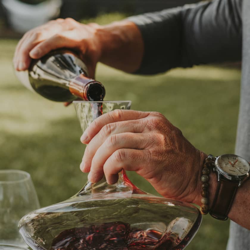Person pouring wine into a decanter